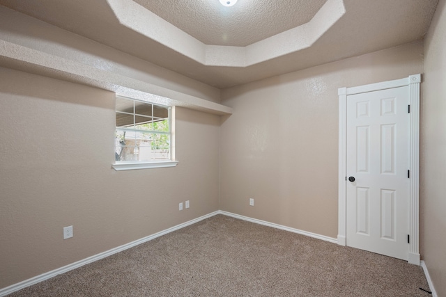 spare room with baseboards, carpet flooring, and a textured ceiling
