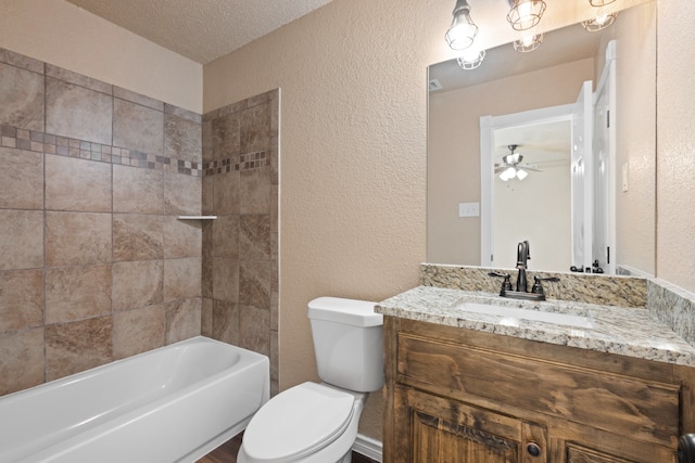 bathroom with ceiling fan, toilet, a textured wall, and vanity
