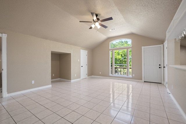 spare room featuring a ceiling fan, a textured ceiling, vaulted ceiling, and light tile patterned floors