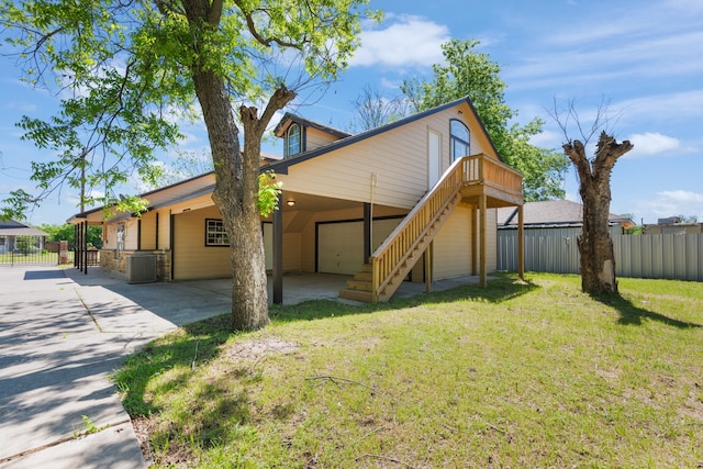 view of front of home featuring fence, central AC, concrete driveway, a front yard, and a garage