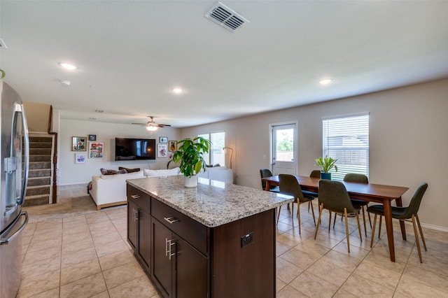 kitchen featuring a center island, stainless steel fridge with ice dispenser, dark brown cabinetry, visible vents, and recessed lighting