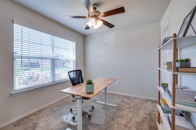 carpeted office featuring ceiling fan and baseboards