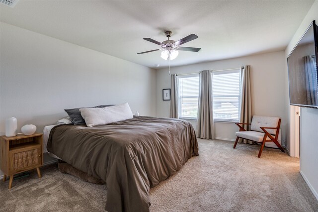 bedroom with visible vents, light carpet, baseboards, and ceiling fan