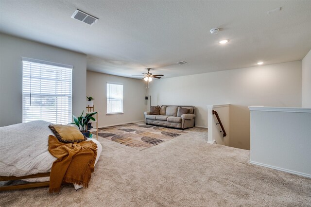 carpeted living area featuring recessed lighting, visible vents, baseboards, and ceiling fan