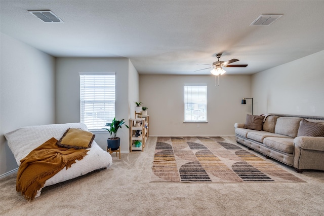living area with a healthy amount of sunlight, carpet flooring, and visible vents