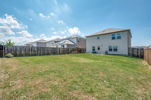 back of house featuring a lawn and a fenced backyard