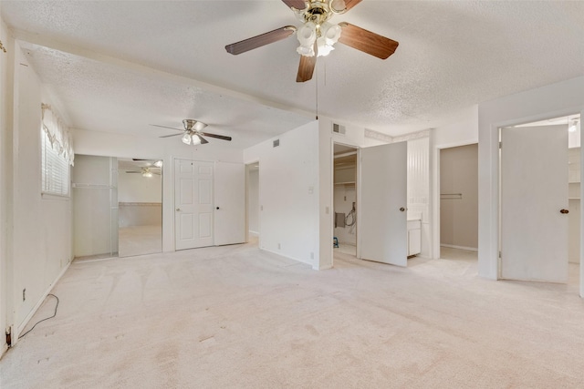 unfurnished bedroom with a textured ceiling, baseboards, visible vents, carpet floors, and connected bathroom