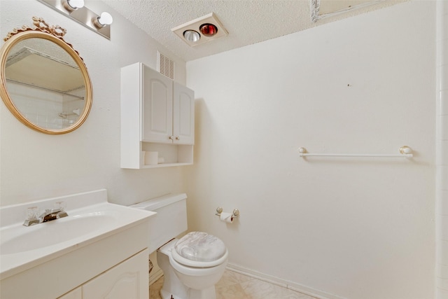 bathroom featuring baseboards, vanity, a textured ceiling, and toilet