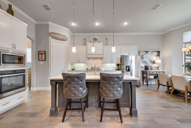 kitchen with crown molding, stainless steel appliances, visible vents, and light countertops
