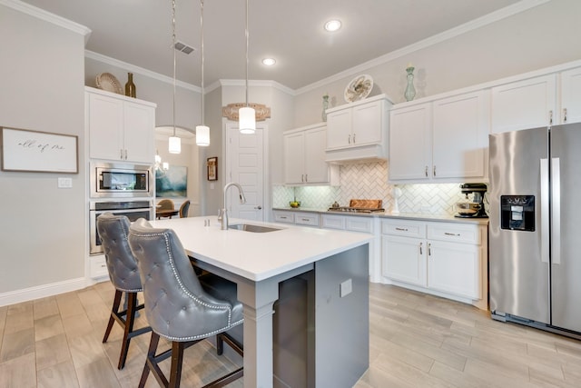 kitchen featuring recessed lighting, light countertops, a sink, decorative backsplash, and appliances with stainless steel finishes