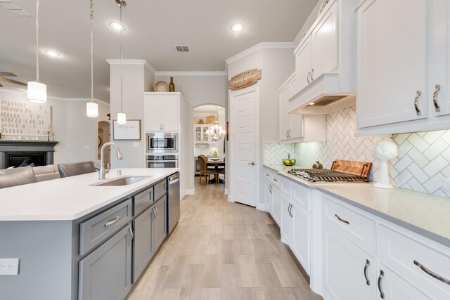 kitchen featuring stainless steel appliances, a sink, visible vents, gray cabinetry, and light countertops