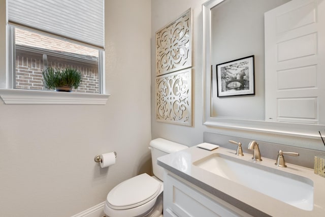 half bathroom featuring vanity and toilet