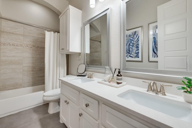 bathroom with toilet, tile patterned floors, a sink, and double vanity