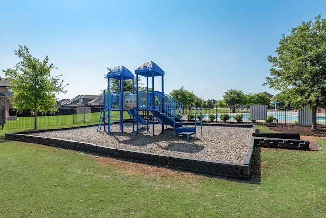 community jungle gym with a yard and fence