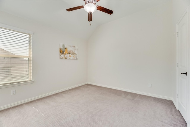 spare room featuring a ceiling fan, baseboards, light colored carpet, and lofted ceiling