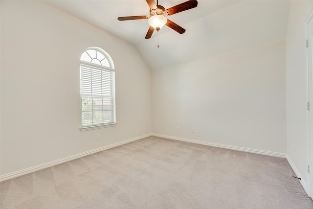 spare room featuring light colored carpet, baseboards, ceiling fan, and lofted ceiling