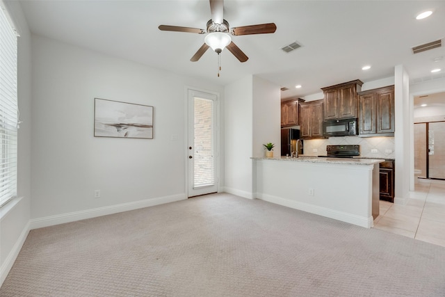 kitchen with visible vents, black appliances, and light carpet