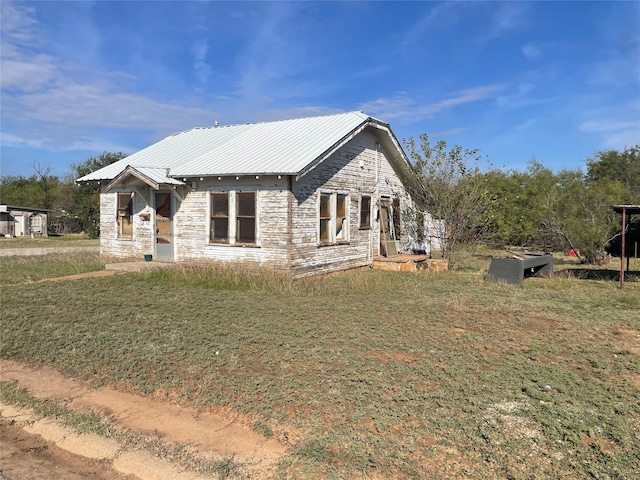 view of front of property featuring stone siding and metal roof
