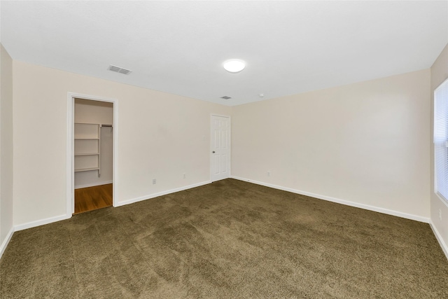 12109 Arbor Lake Rd, Rhome, TX 76078 - unfurnished bedroom featuring baseboards, dark colored carpet, visible vents, and a walk in closet