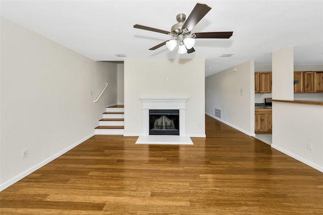 12109 Arbor Lake Rd, Rhome, TX 76078 - unfurnished living room featuring light wood-style flooring, visible vents, a ceiling fan, and stairs