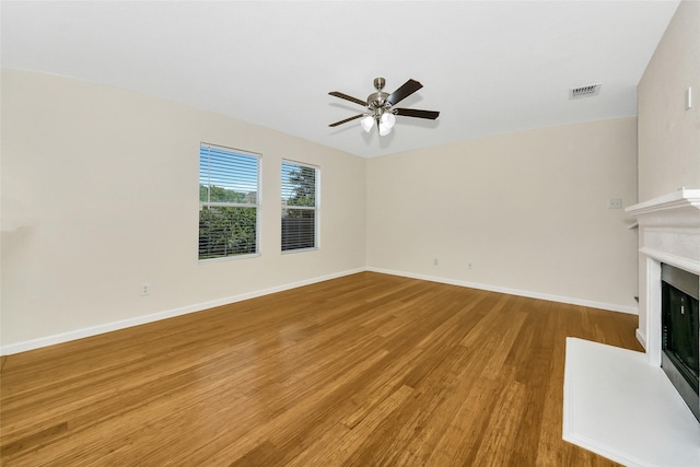 12109 Arbor Lake Rd, Rhome, TX 76078 - unfurnished living room with a fireplace with flush hearth, wood finished floors, visible vents, baseboards, and ceiling fan