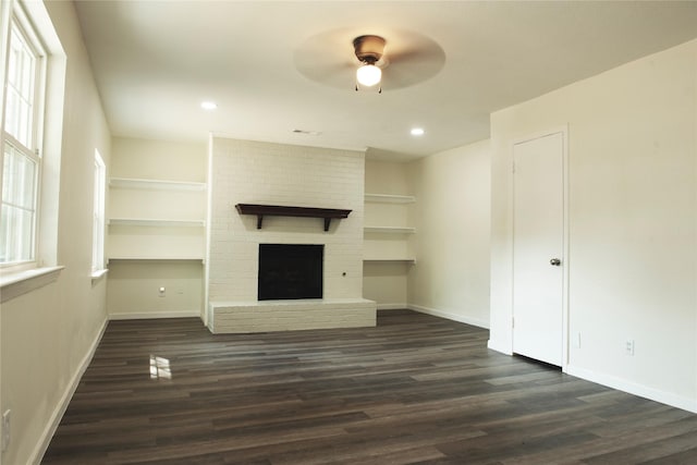 unfurnished living room with a ceiling fan, baseboards, a fireplace, built in features, and dark wood-style flooring