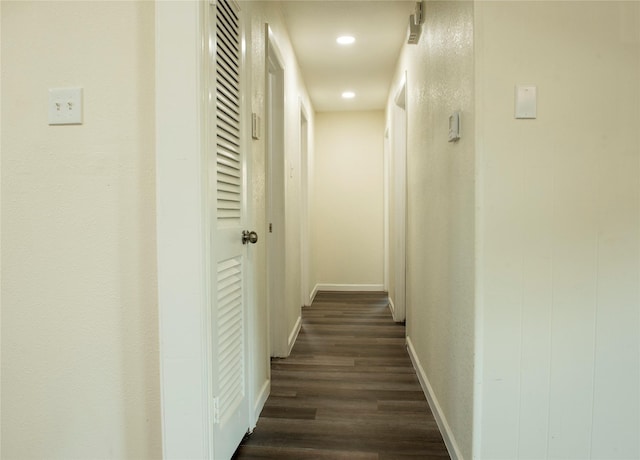 hall with dark wood finished floors, baseboards, and recessed lighting