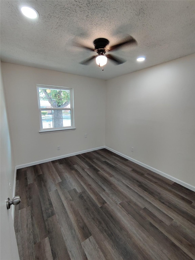 empty room featuring a textured ceiling, ceiling fan, dark wood finished floors, baseboards, and recessed lighting