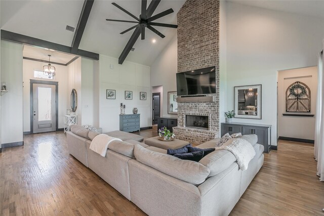 living area with high vaulted ceiling, baseboards, and wood finished floors
