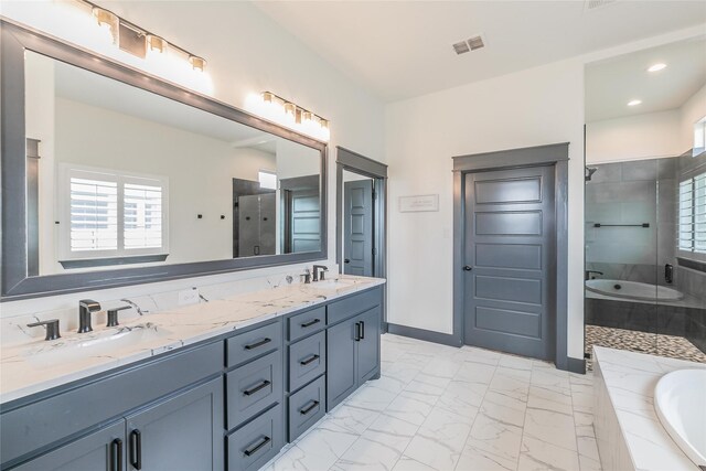 full bath featuring marble finish floor, a sink, a shower stall, and visible vents