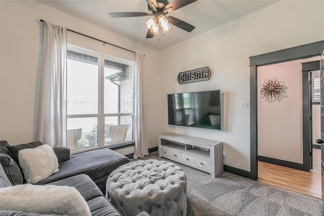 living room featuring a ceiling fan, baseboards, carpet, and plenty of natural light