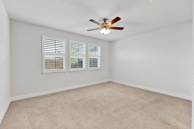 empty room featuring carpet, baseboards, and ceiling fan