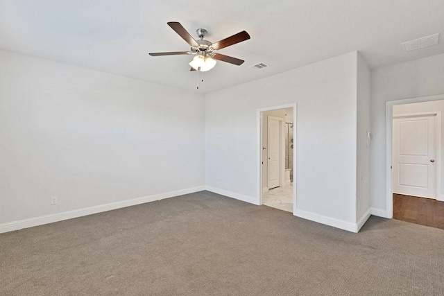 carpeted spare room with ceiling fan, baseboards, and visible vents