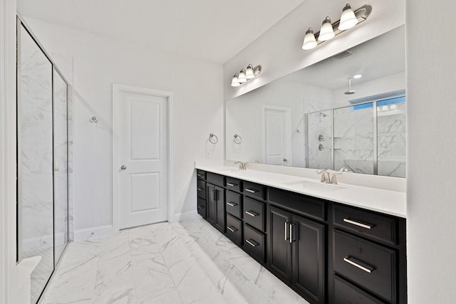 full bath with marble finish floor, a sink, a marble finish shower, and double vanity