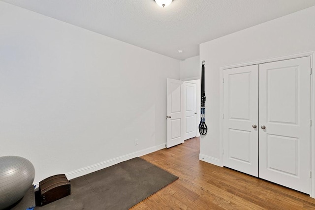 interior space with baseboards, wood finished floors, and a closet