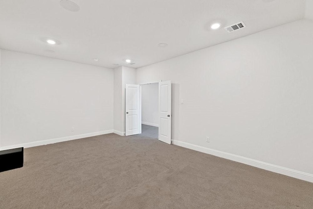 empty room with baseboards, dark colored carpet, visible vents, and recessed lighting