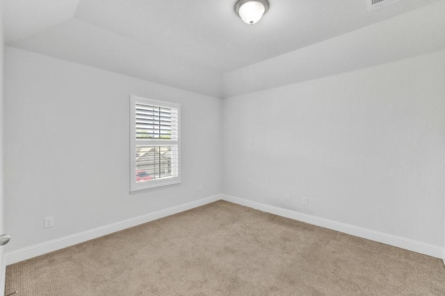 spare room with lofted ceiling, baseboards, and carpet floors