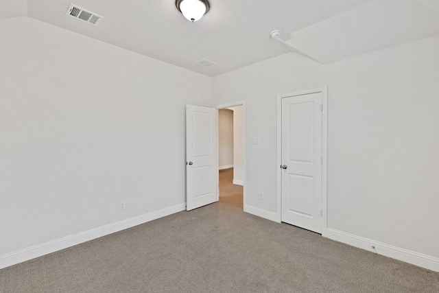 carpeted spare room featuring baseboards and visible vents