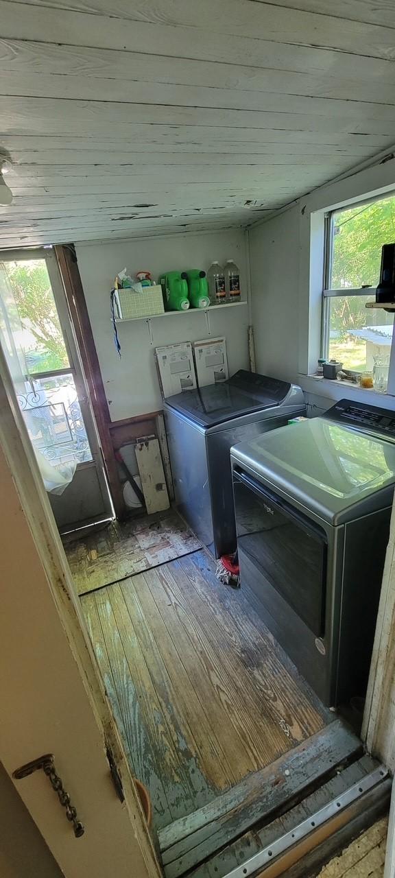 laundry area featuring wood finished floors, wood ceiling, washer and dryer, and laundry area