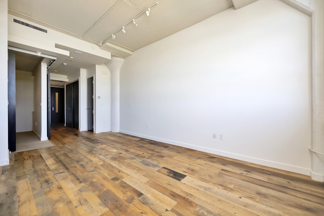 spare room featuring hardwood / wood-style flooring, baseboards, and visible vents