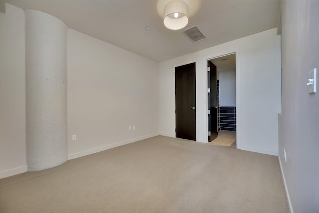 unfurnished bedroom featuring baseboards, carpet flooring, and visible vents