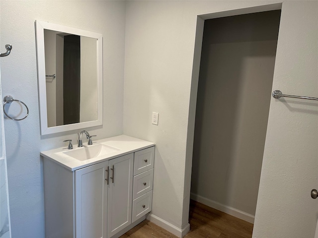 bathroom featuring baseboards, wood finished floors, and vanity