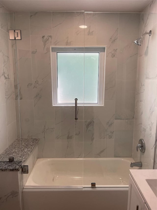 bathroom featuring combined bath / shower with glass door and vanity