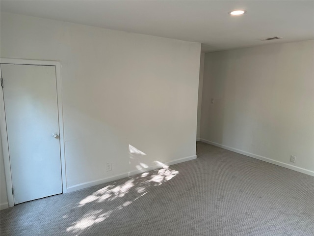 empty room with baseboards, visible vents, carpet, and recessed lighting