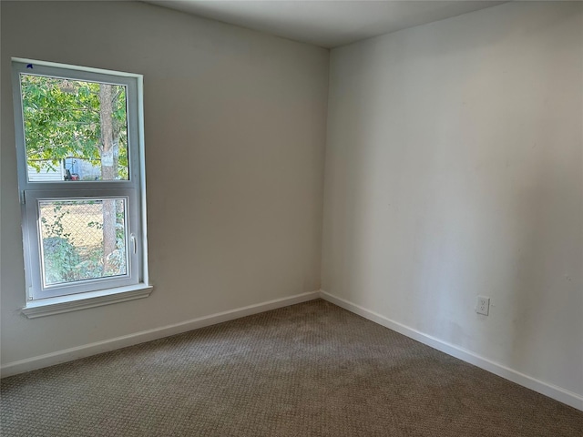 carpeted empty room with baseboards and plenty of natural light