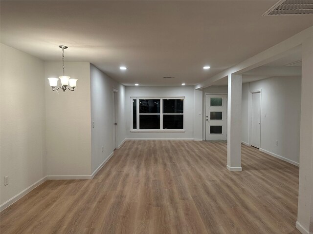 interior space featuring baseboards, wood finished floors, and visible vents