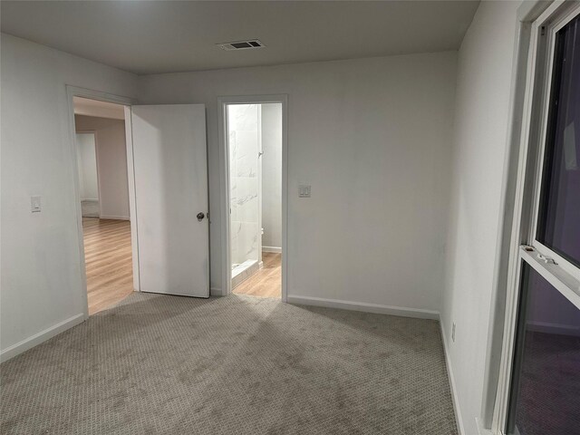 unfurnished room featuring carpet floors, visible vents, and baseboards