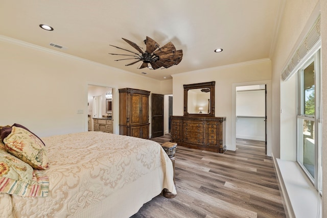 bedroom with visible vents, wood finished floors, and crown molding