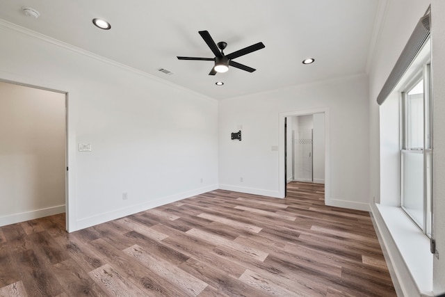 empty room with baseboards, a ceiling fan, wood finished floors, and crown molding