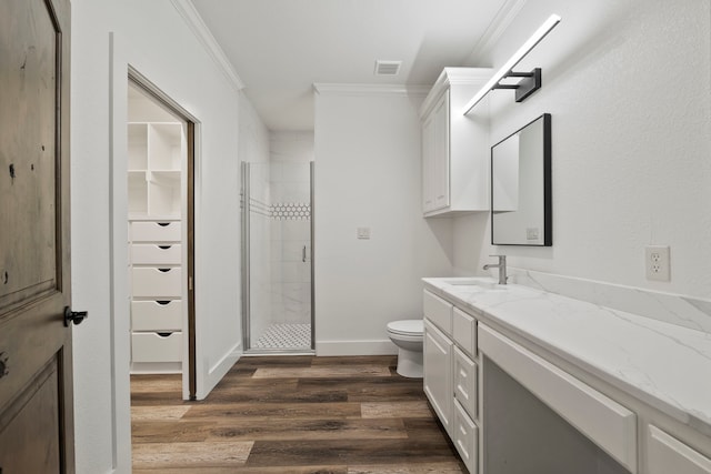 full bath with a shower stall, visible vents, toilet, ornamental molding, and wood finished floors